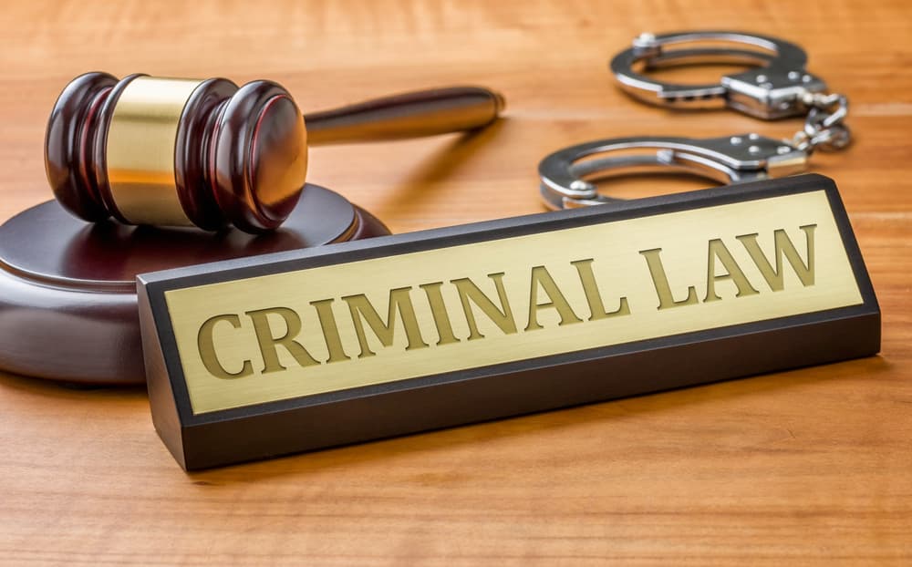A gavel beside a nameplate engraved with "Criminal Law."