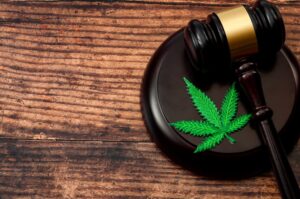 Drug concept theme with a marijuana leaf and a wooden gavel 